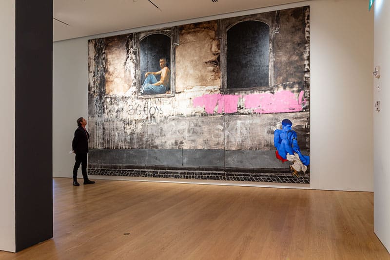 Installation View Photo: Joern Rohde Curtis Collins, Director & Chief Curator in front of Attila Richard Lukacs, Everybody Wants The Same Thing, (detail)1993. Promised Gift of Martha Sturdy to Audain Art Museum Collection.